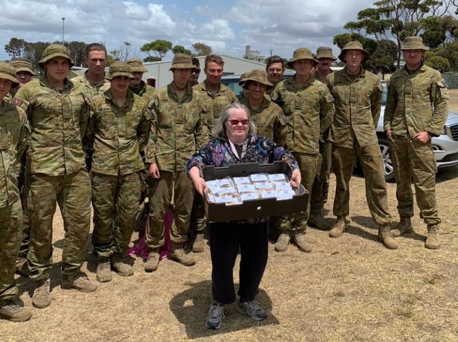 Barb giving muesli bars to the army on Kangaroo Island after the fires.